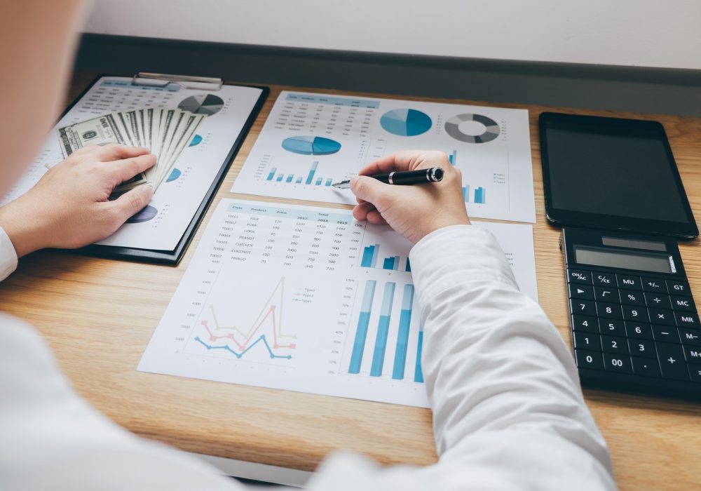 businessman working on a graph document financial report and analysis calculation investment cost